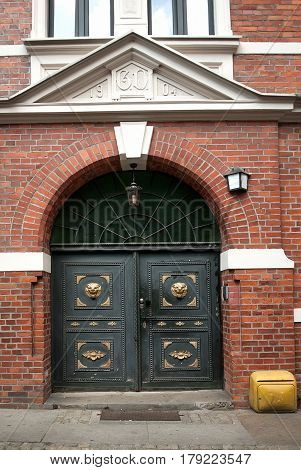 Old wooden door with lions and lamp