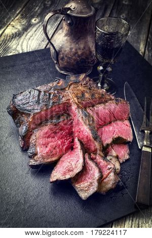 Barbecue dry aged Wagyu Bistecca alla Fiorentina as close-up on a black slate 