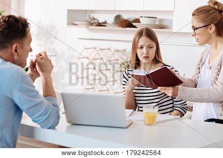 Try harder. Sctrict parents checking grades of their daughter and scolding her for bad results while sitting in the kitchen