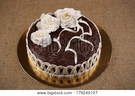 Chocolate cake decorated white fondant flowers. Bakery. Sweet food. Homemade cake.