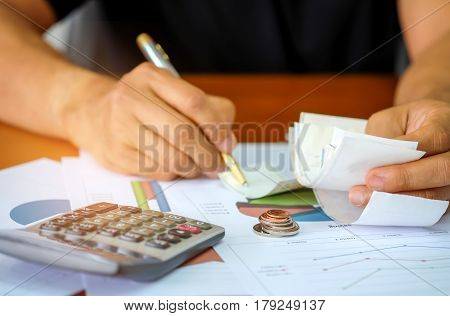 Men are using a calculator to analyze slip credit card.