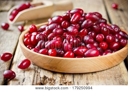 Organic cornel or dogwood berry in a wooden bowl