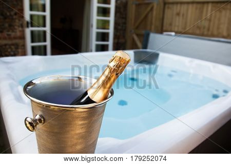 bottle of champagne cooling by hot tub 