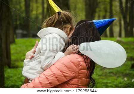 Mom hugs her daughter 8 years in a spring park