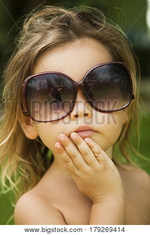 The little girl wears a large adult sunglasses Asian-mestizo