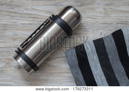 Thermos flask made of stainless steel on a woden background. Top view