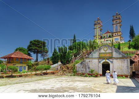 Towers of the Thanh That Da Phuoc on blue sky background. Scenic view of the temple for the Cao Dai religion adherents at Dalat (Da Lat) Vietnam. Dalat is a popular tourist destination of Asia.