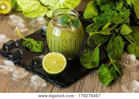 Detox diet. Green smoothie with fruits and vegetables on wooden dark background.