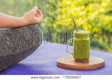 Closeup Of A Woman's Hands During Meditation With A Green Smoothies Of Spinach, Orange And Banana