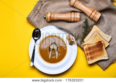 Cream Soup Brown Color With Fish, Toast, Pepperbox, Thyme, Saltcellar