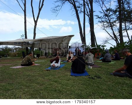 NORTH SHORE - FEBRUARY 19: Outdoor Yoga class among large ironwood trees at Optimysstique Campout 2017. February 19 2017 Oahu Hawaii.