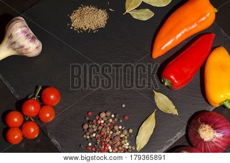 Vegetables and spices before cooking dinner on a dark background top view copyspace.