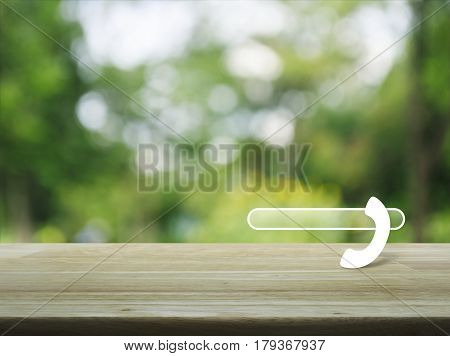 Phone icon with copy space for add your phone number on wooden table over blur green tree background Contact us concept