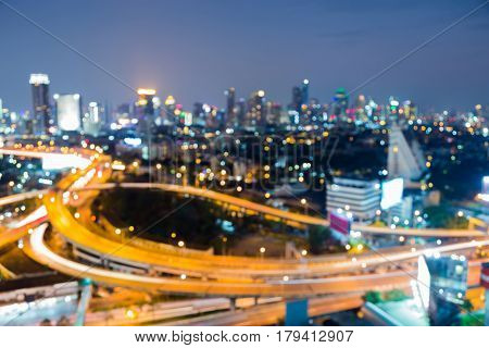 Aerial view city downtown and interchanged overpass blurred bokeh light night view abstract background