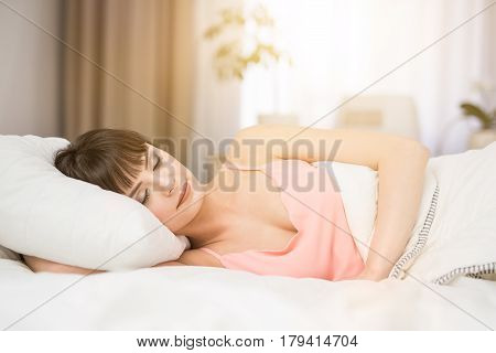 Beautiful young woman sleeping on a bed in the bedroom. A peaceful sleep makes you happy.