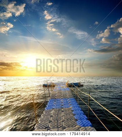 Pontoon with handrails in the sea at sunset