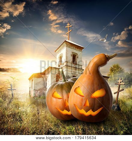 Halloween pumpkins on a churchyard near old church