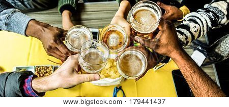 Top view of friends cheering with home brew in pub bar restaurant - Young people hands toasting and beers half pint - Party concept - Warm contrast filter filter - Focus on bottom right and left hand