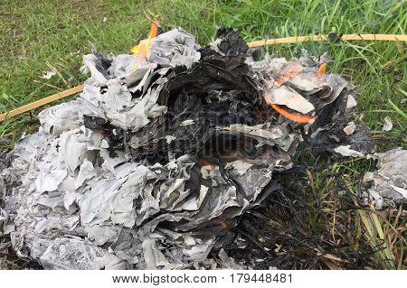 Burning Silver and gold paper and hat to worship ancestor in Chinese culture, the Qingming Festival at graveyard Cemetery