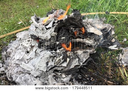 Burning Silver and gold paper and hat to worship ancestor in Chinese culture, the Qingming Festival at graveyard Cemetery
