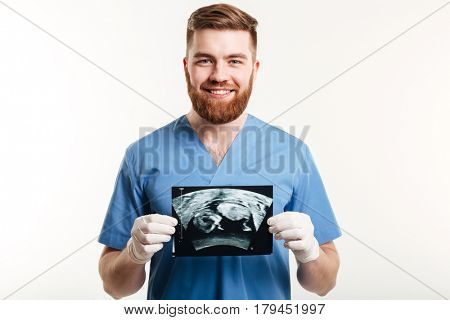 Portrait of a smiling young male medical doctor or nurse showing radiograph x-ray image isolated on white background