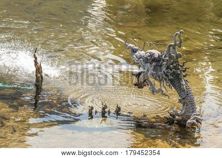 Closeup of naka or serpent statue were sprayed water.