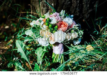 Lush beautiful wedding bouquet under the tree.