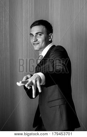 Happy man in a suit is standing near the wall. Man portrait. Businessman.