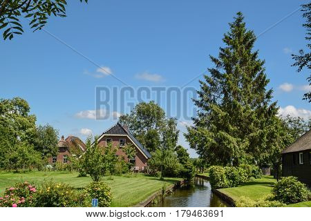 GIETHOORN NETHERLANDS JUNE 6 2016: Giethoorn, theVenice of the north, is located in the Weerribben-Wieden National Park is an idyllic village in Overijssel where many thatched-roof farms were built on small islands joined by more than 170 little bridges.
