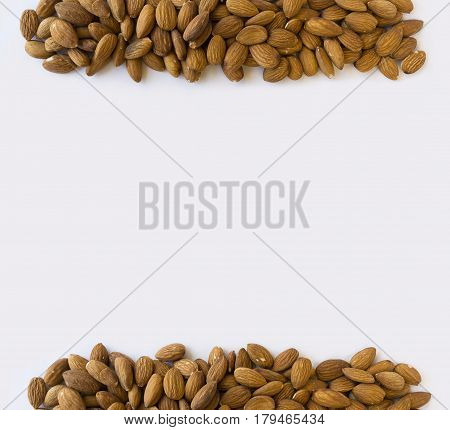 Almonds at border of image with copy space for text. Kernels almonds on a white background. Top view. Vegetarian or healthy eating. Background of almond.
