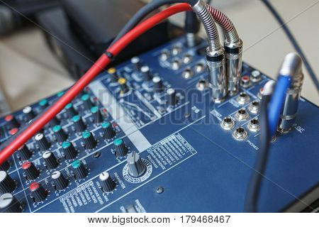 DJ mixer for sound effects and acoustic systems connection. Connected audio cables to a special sound console. Tools DJ and musicians.