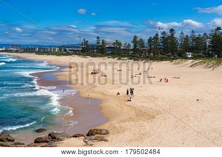 Aerial view of Wollongong beach with unrecognisable people relaxing and sunbathing under the summer sun