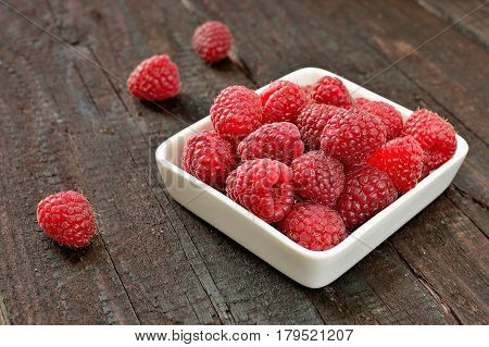 Raspberry fruit on wood background. Forest fruit in white idaeus. Delicious fresh berries.