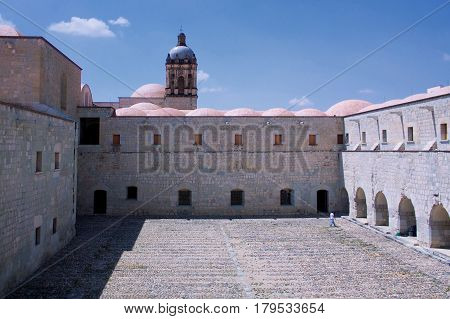Mexico Oaxaca Santo Domingo monastery courtyard view with church tower and loney figure