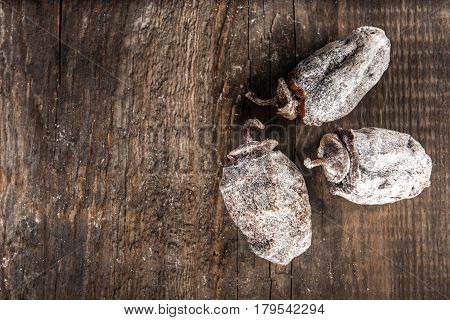 Dried persimmon fruits on wooden background. Oriental sweets