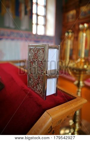The Gospel and the iconostasis and candles in the orthodox church