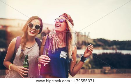 Happy friends laughing and having fun outdoors at concert