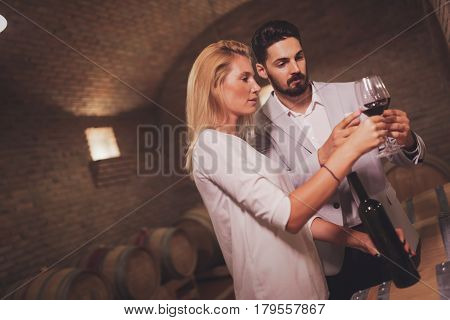 Wine loving couple tasting wines in winery cellar
