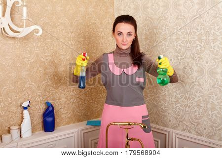 Woman in uniform and gloves with cleaning agent