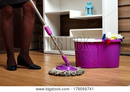 Female hands in rubber gloves wash floor with rag
