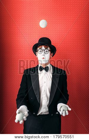 Pantomime male actor juggles with balls