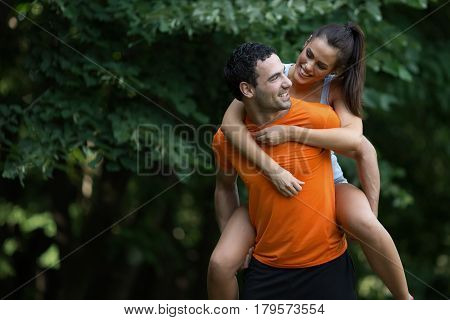 Happy sporty couple hacing fun after jogging in nature