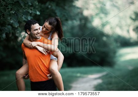 Happy sporty couple hacing fun after jogging in nature