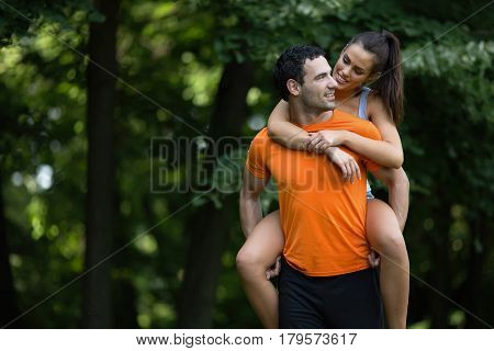 Happy sporty couple hacing fun after jogging in nature