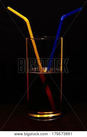 A glass filled with a drink in which two tubes were inserted - as a symbol of friendship between people