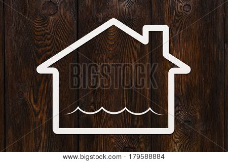 Paper house with water waves inside deluge or flooding abstract conceptual image on wooden background
