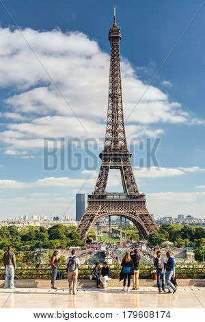 PARIS - SEPTEMBER 20: Tourists walk on a viewing platform in front of the Eiffel Tower on september 20, 2013 in Paris. The Eiffel tower is one of the major tourist attractions of France.