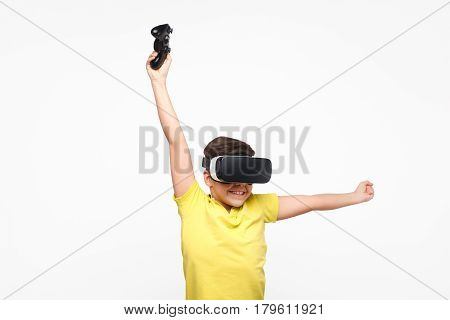 Boy holding up hand with the controller during the virtual reality experience.