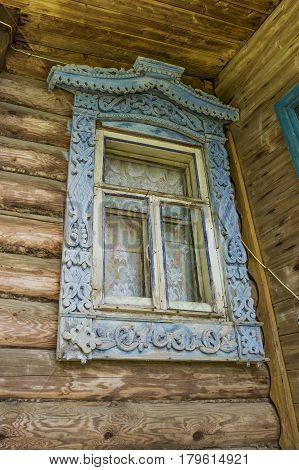 Old window of a village house with carved platbands