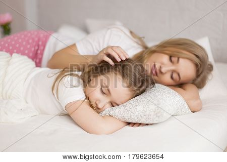 mother put her daughter to sleep. White interior
